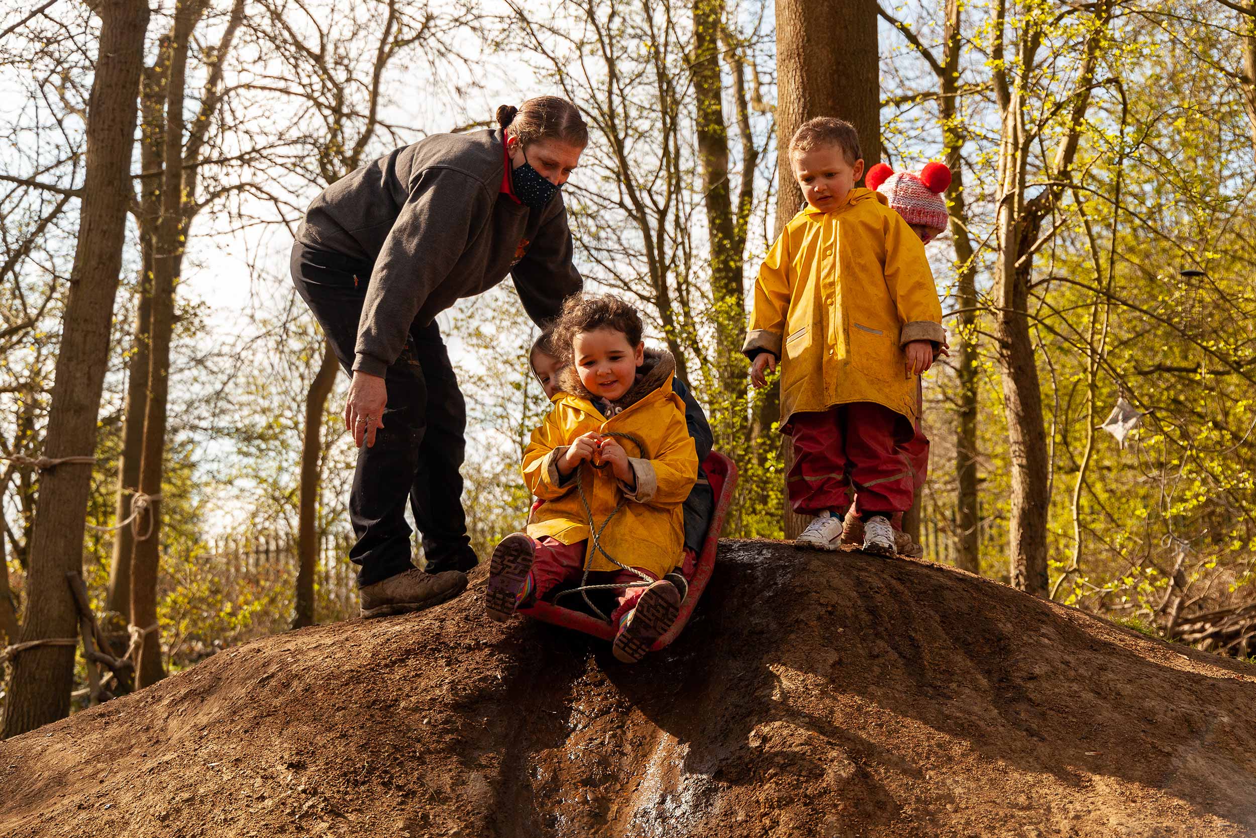 Children sliding down a mud hill