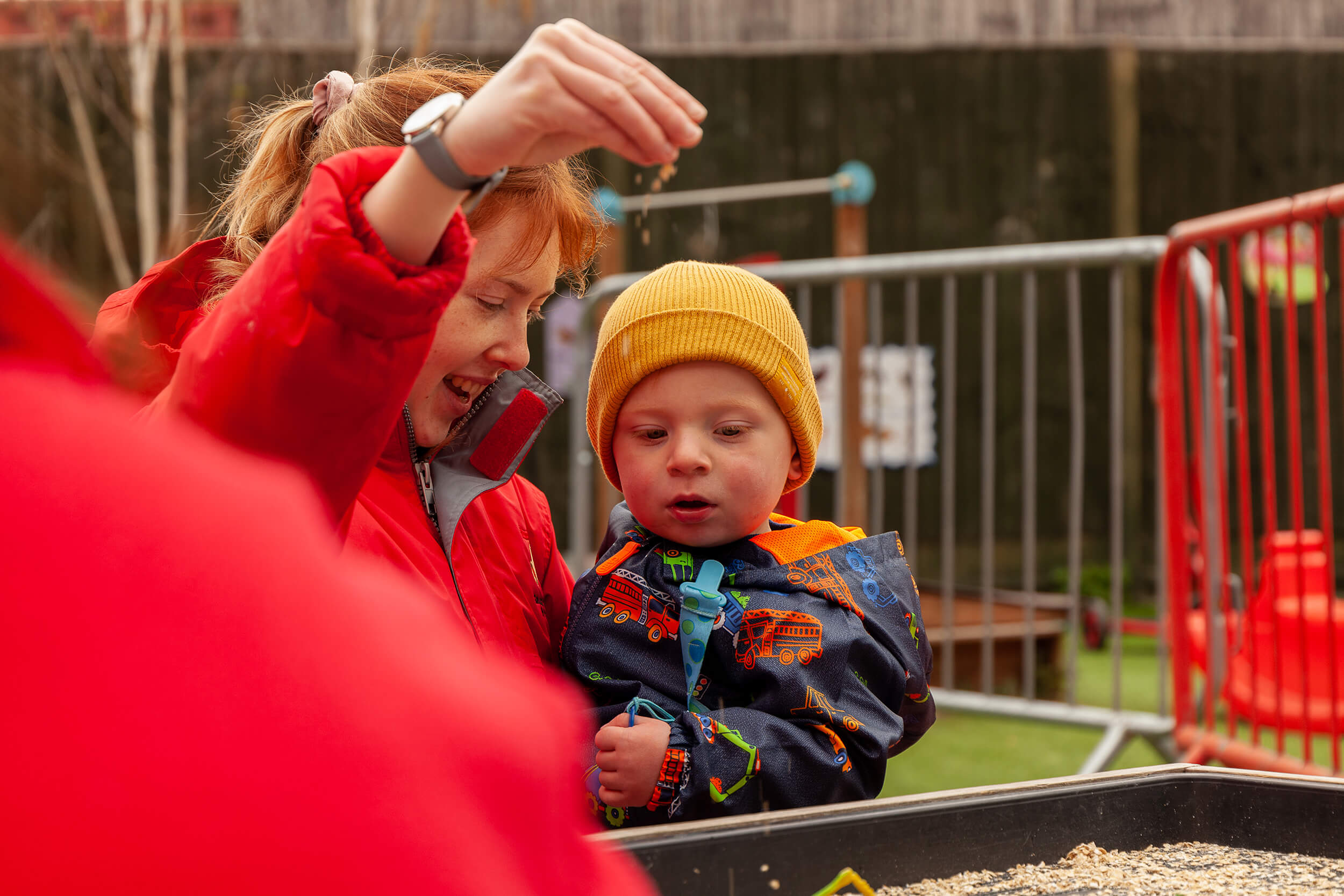 Nursery Nurse and boy playing with sand