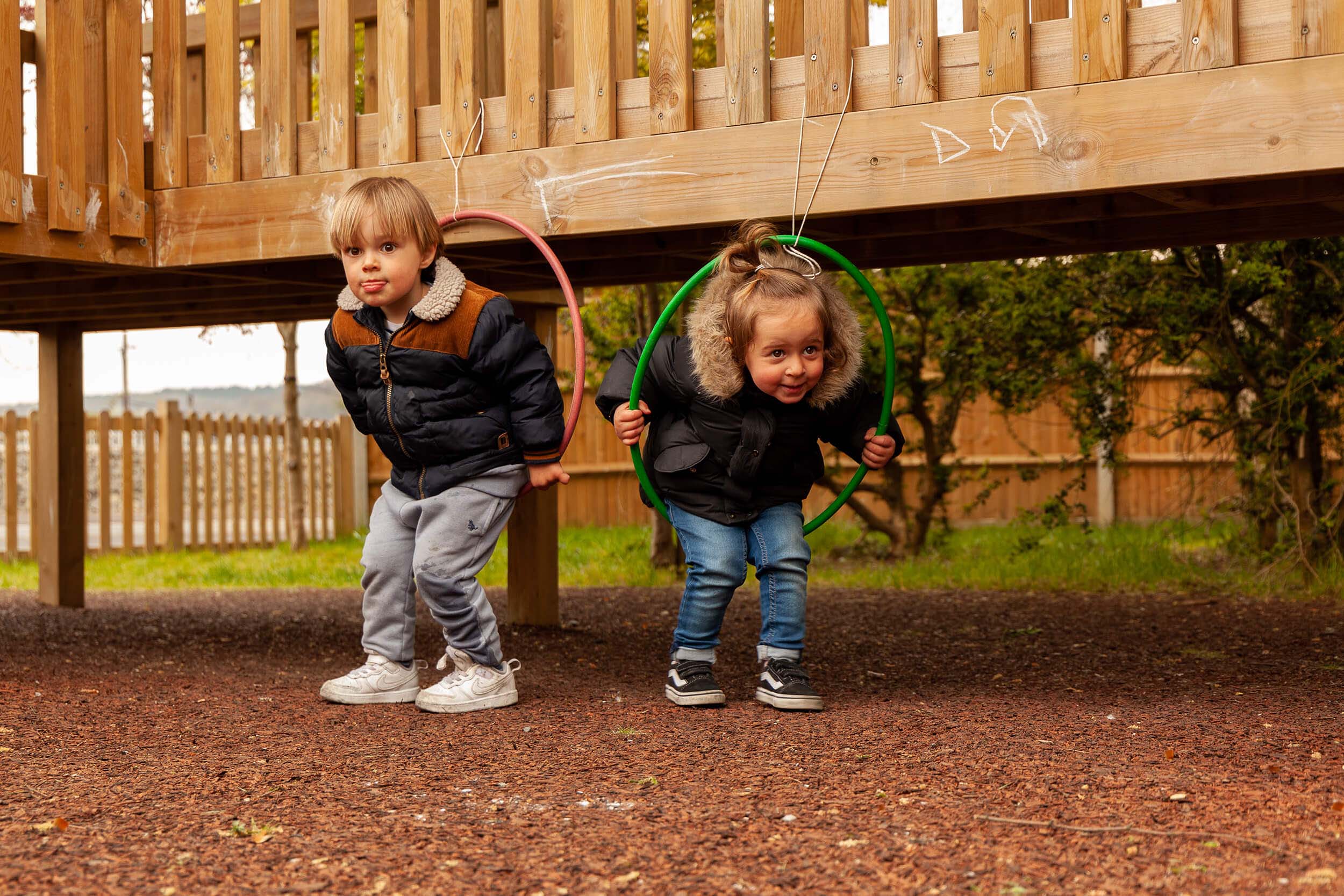 A boy and a girl playing on hoops