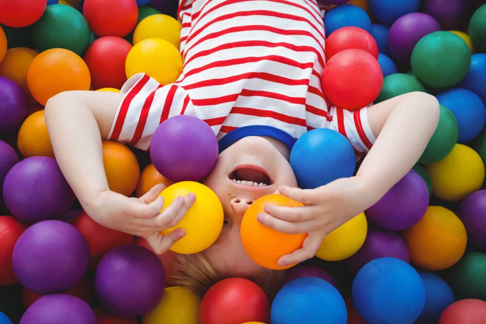 Kid in a colourful ball pit