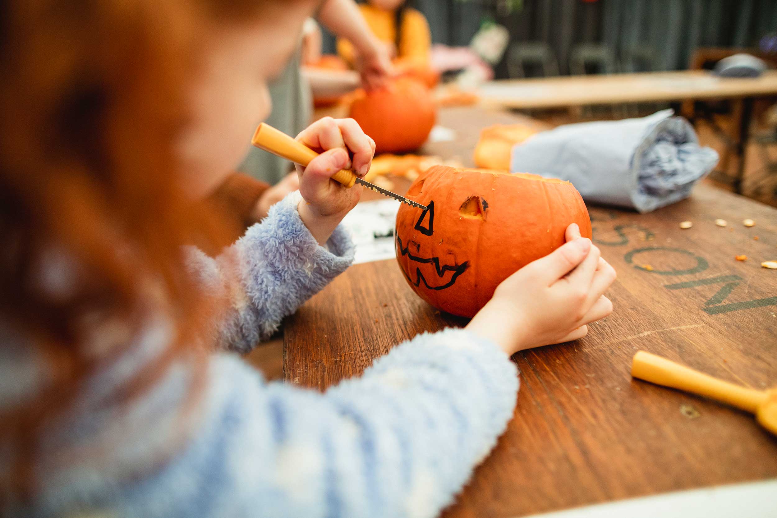 Child carving a pumpkin