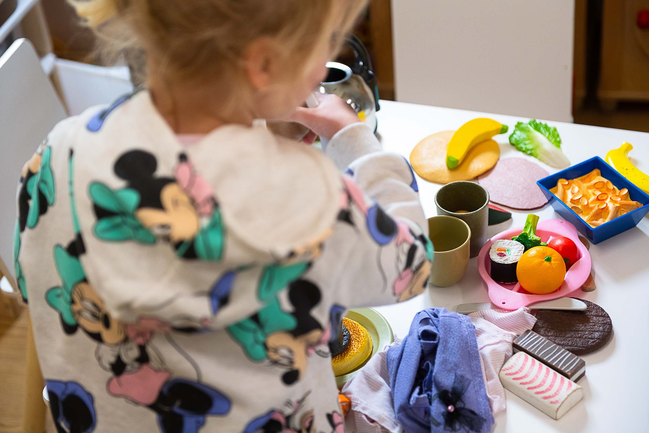 A little girl playing with toy food