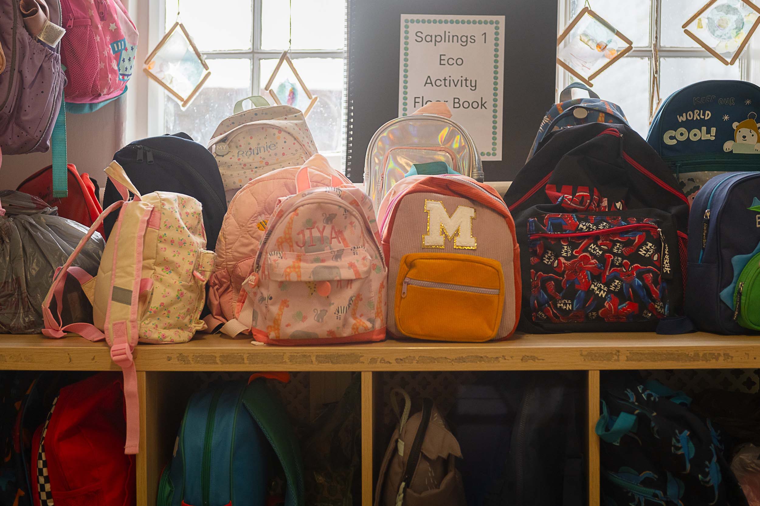 Childrens backpacks along a shelving area