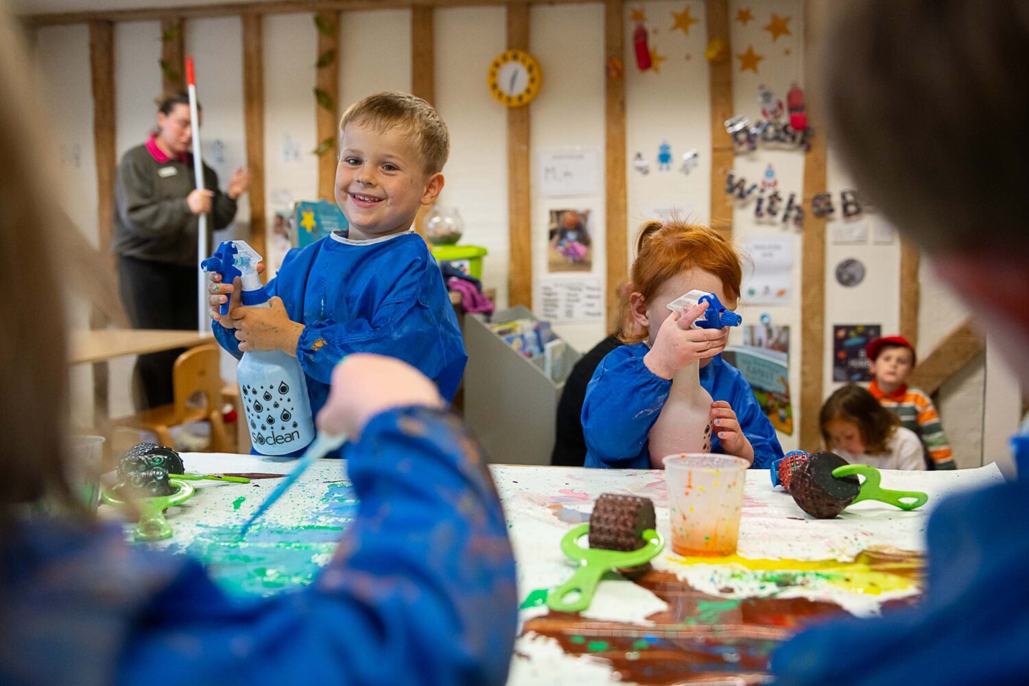 young children playing with spray bottles of pain