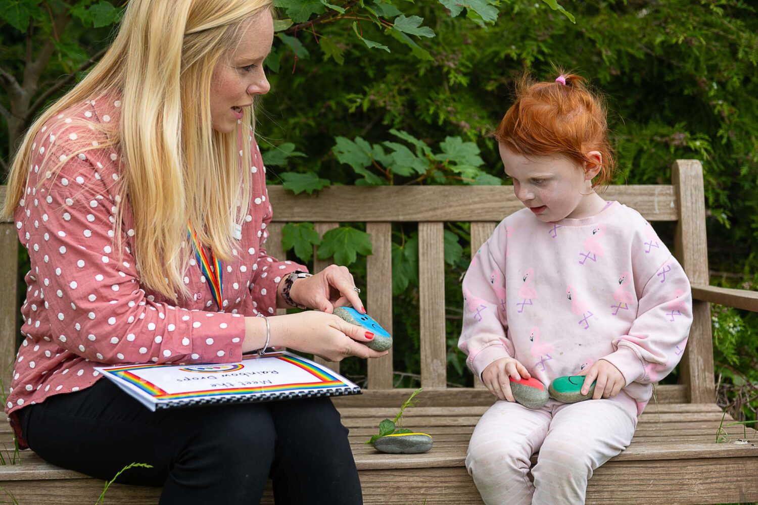 A SEN staff member working with a young girl, using the pebbles representing emotions