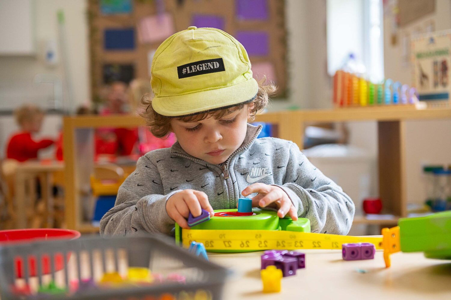 little boy playing with a toy tape measure